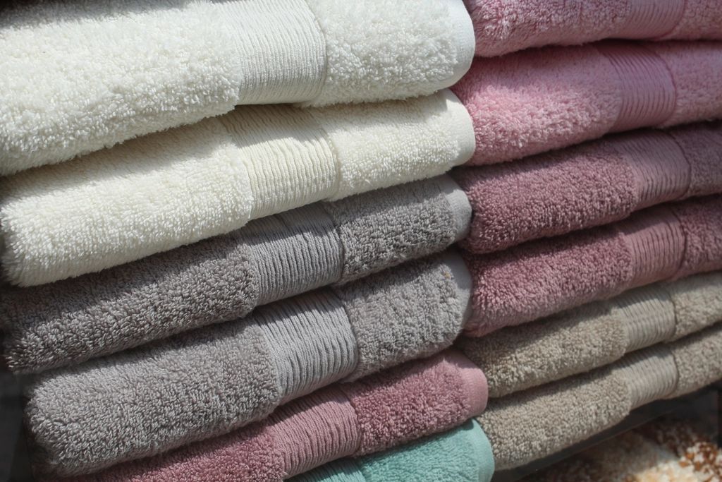 Folded bath towels stacked in neat piles.